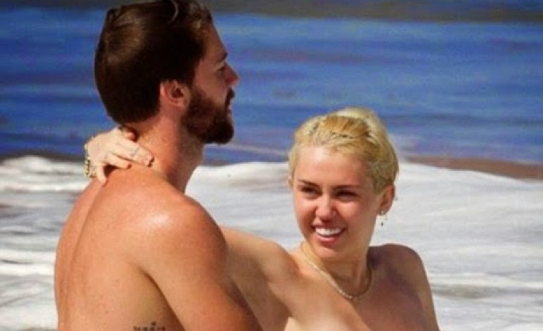Miley Cyrus goes topless as she frolics in the ocean with boyfriend
