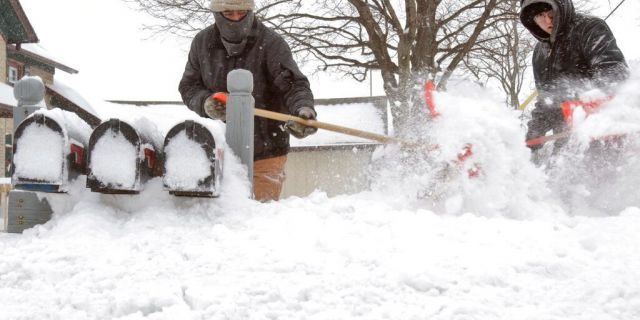 Ausencio Castaneda of Kewaskum, left, clears a path to a series of mailboxes outside a multi-family home with his son Ausencio Castaneda Jr. onMonday, Jan. 28, 2019, in Kewaskum, Wis. A number of inches of snow accumulated in Washington County Sunday Sunday night through Monday. (John Ehlke/West Bend Daily News via AP)