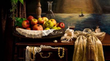 A wooden stand covered in fruit in front of a painting of a ship at sea
