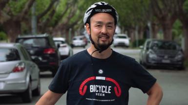 Man standing in street wearing bike helmet